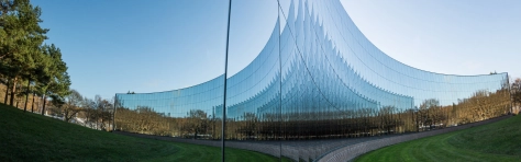 An image of a modern office building with mirror windows reflecting the rural surroundings. 